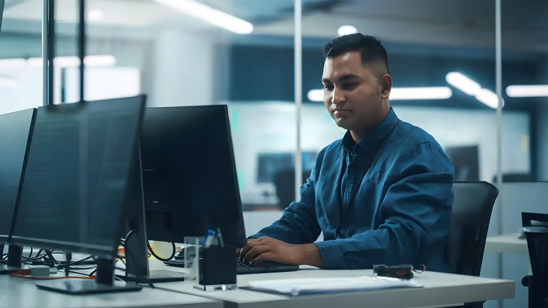 Native American IT professional typing on a computer in a Native American-owned business